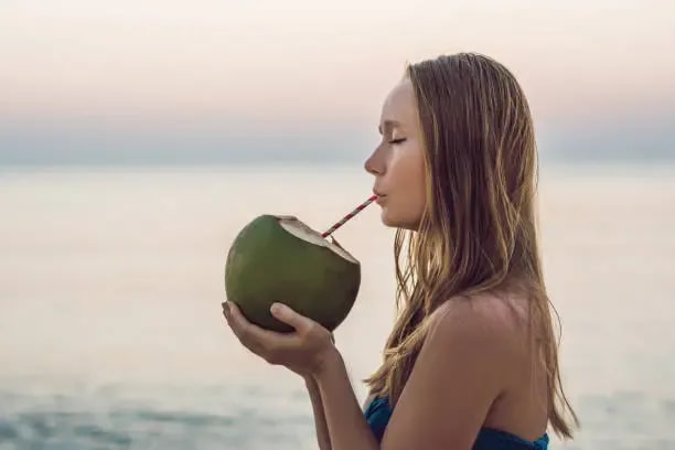 image of a woman drinking coconut water
